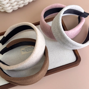 Detail of four padded wool headbands in brown, beige, pink and gray on a tray