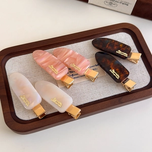 Chic 6-piece acetate hair clips set in pearl white, pink and tortoiseshell with gold emblems
