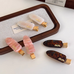 Colorful acetate marble pattern hair clips with golden accents for women