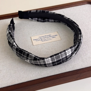 Détail de la texture du tissu écossais noir et blanc et des dents antidérapantes du bandeau
