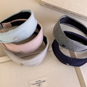 Detail view of cotton padded headbands with small metal heart charms in five colors