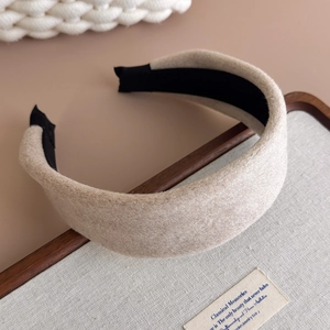 Detail of a wide beige wool hairband with velvet texture and non-slip inner lining