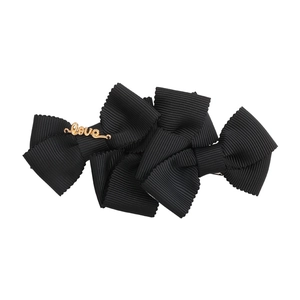 Elegant black layered ribbon bow hair clip with gold Love metal lettering on white background