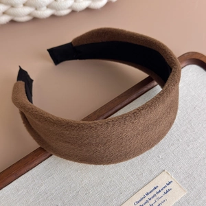 Close-up of wide coffee plush headband with faux rabbit fur texture and black fabric lining