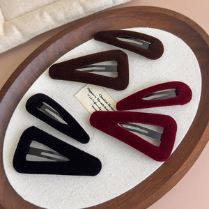 Lot de 6 barrettes en velours vintage noires, marron et bordeaux sur un plateau bois