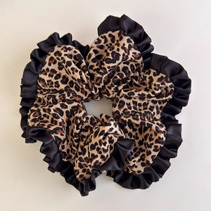 Detail view of large leopard print scrunchie with black satin pleated trim