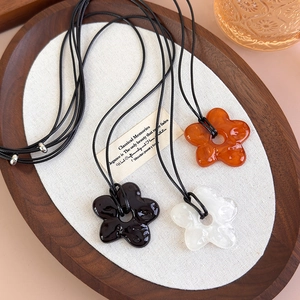 Colliers avec pendentifs fleurs en acrylique aux textures ambre, noir et blanc élégant
