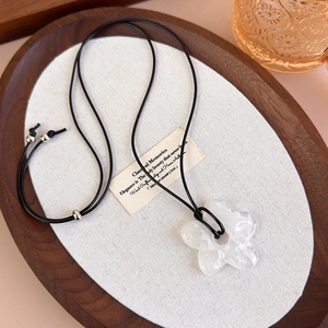 Détail du pendentif fleur transparent sur cordon noir avec perle argentée ajustable