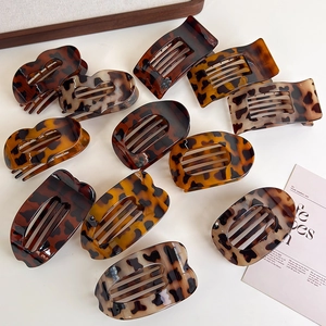 Flat lay of leopard print hair claws in various shapes with premium glossy finish