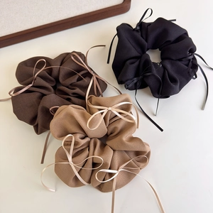 Detailansicht der kaffeebraunen Stoff-Scrunchies mit eleganten Bandschleifen
