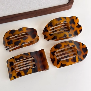 Flat leopard print claw clips set in various shapes on a clean minimalist background