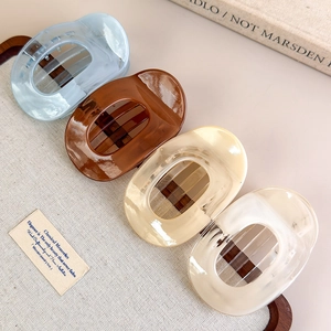 Four-piece set of macaron-colored acetate hair claws with marble texture in a wooden tray