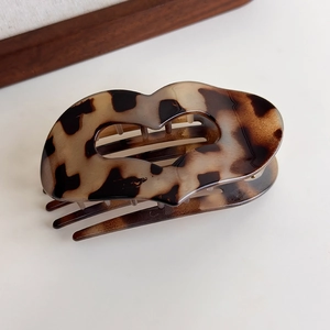 Close-up of leopard print acetate hair claw clip with a stylish lip-shaped design