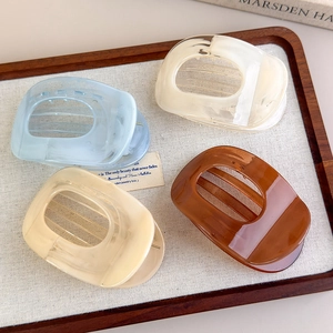 Detailed view of resin hair clips in macaron colors on a tray with polished finish