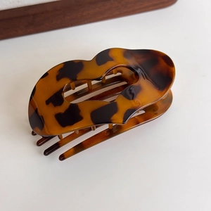 Detailed view of leopard print hair claw clip with glossy tortoiseshell finish