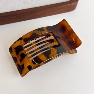 Detail view of large leopard print flat hair claw clip with glossy finish and metal spring