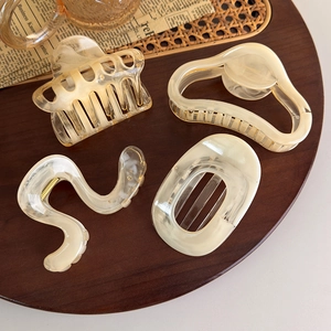 Detailed texture of jelly amber tortoise hair claws on a vintage wooden tray