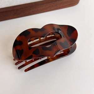 Detailed view of leopard print lip-shaped hair claw clip with shell texture