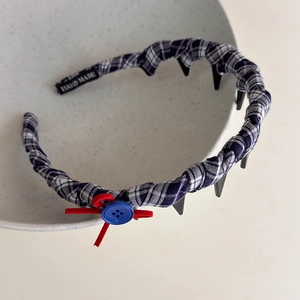 Detail of vintage plaid headband featuring a red bow, blue button, and non-slip hair comb