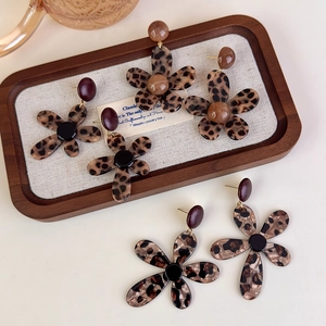 Retro leopard print flower earrings in acrylic material on a wooden tray background
