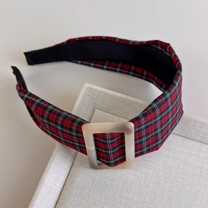Close-up of tartan plaid headband with marble-patterned square buckle on a tray