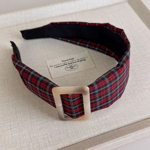 Detail shot of vintage plaid headband with a faux-marble resin buckle on woven surface