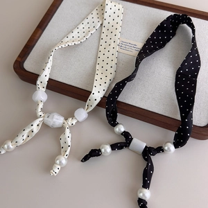 Collana in seta a pois con grandi perle e perline geometriche nei colori nero e bianco