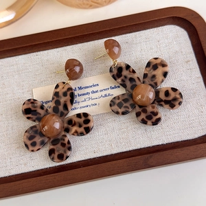 Detail of leopard print flower earrings in brown resin with gold-toned metal posts