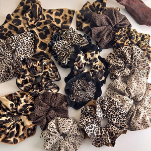 Collection of stylish leopard print scrunchies and hair ribbons on a white background