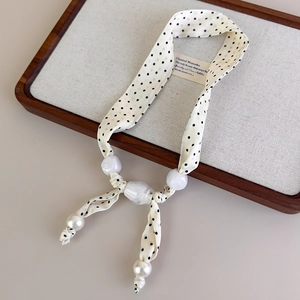 Dettaglio della collana foulard a pois con perle bianche e perline marmorizzate