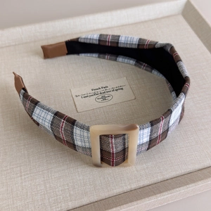 Detailed close-up of brown checkered headband with marble pattern square buckle