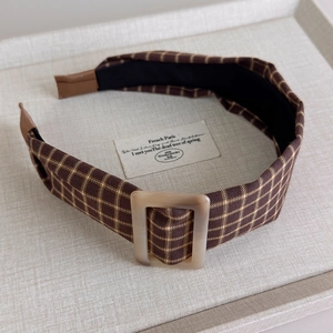 Detail view of a vintage brown plaid headband with a square resin buckle and anti-slip lining