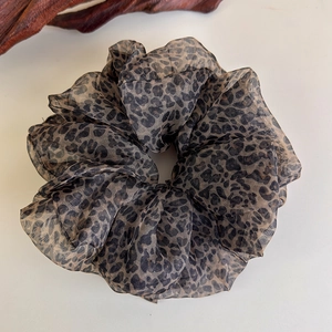 Close-up of leopard print chiffon hair scrunchie with soft pleated texture and semi-sheer fabric