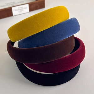 Close-up of five velvet headbands in various colors showing soft texture and thick design