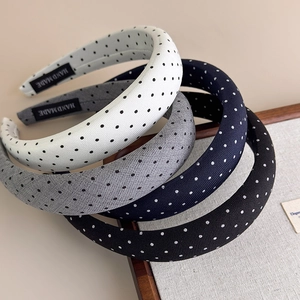 Dettaglio di cerchietti imbottiti a pois in vari colori con etichette fatte a mano