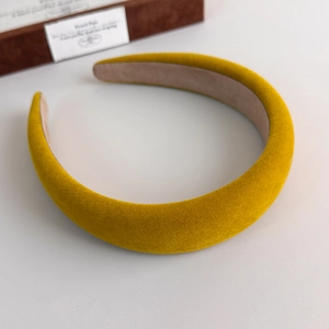Macro shot of bright yellow velvet headband with padded design and non-slip lining detail