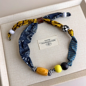 Close-up of bohemian fabric beaded necklace with leopard print and knot details