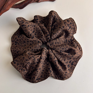 Detail of leopard print scrunchie with soft fabric texture and elastic design