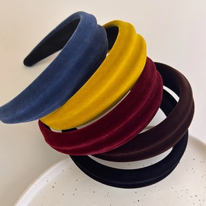 Close-up of assorted padded velvet headbands in navy, gold, burgundy, brown, and black