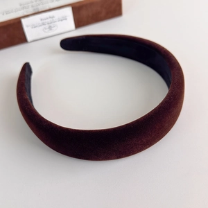 Detailed view of dark brown velvet headband with thick padded texture and soft sheen