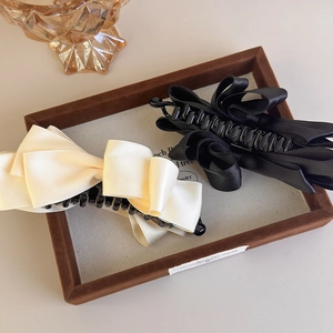 Elegant multi-layered satin bow banana hair clips in cream and black for high ponytails