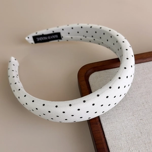 Dettaglio di cerchietto bianco a pois fatto a mano con etichetta interna hand made