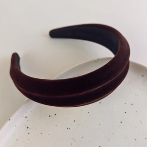 Close-up of thick coffee brown velvet headband on a decorative ceramic tray