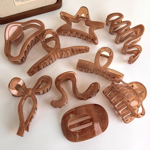Amber brown jelly hair claw set with star and bow shapes on a minimalist white background