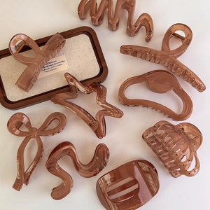 Detailed close-up of jelly brown hair claw clips in various geometric and bow shapes