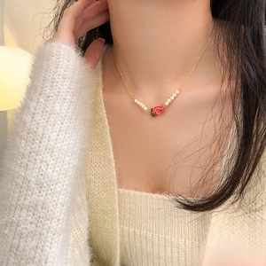 Detail of a french style rose necklace featuring pink flower pendant and white small pearls