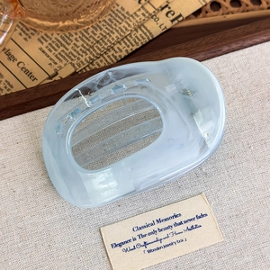 Close-up of blue marble pattern acetate hair claw clip with vintage aesthetic detail