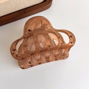 Close-up of a jelly amber hair claw clip featuring a translucent resin texture and metal spring