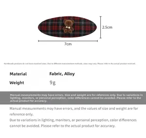 Detail of red and black plaid oval hair clip featuring a cute 3D fuzzy teddy bear ornament
