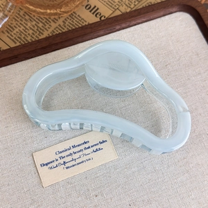 Detailed side view of a jelly blue wavy hair claw clip made of translucent acrylic